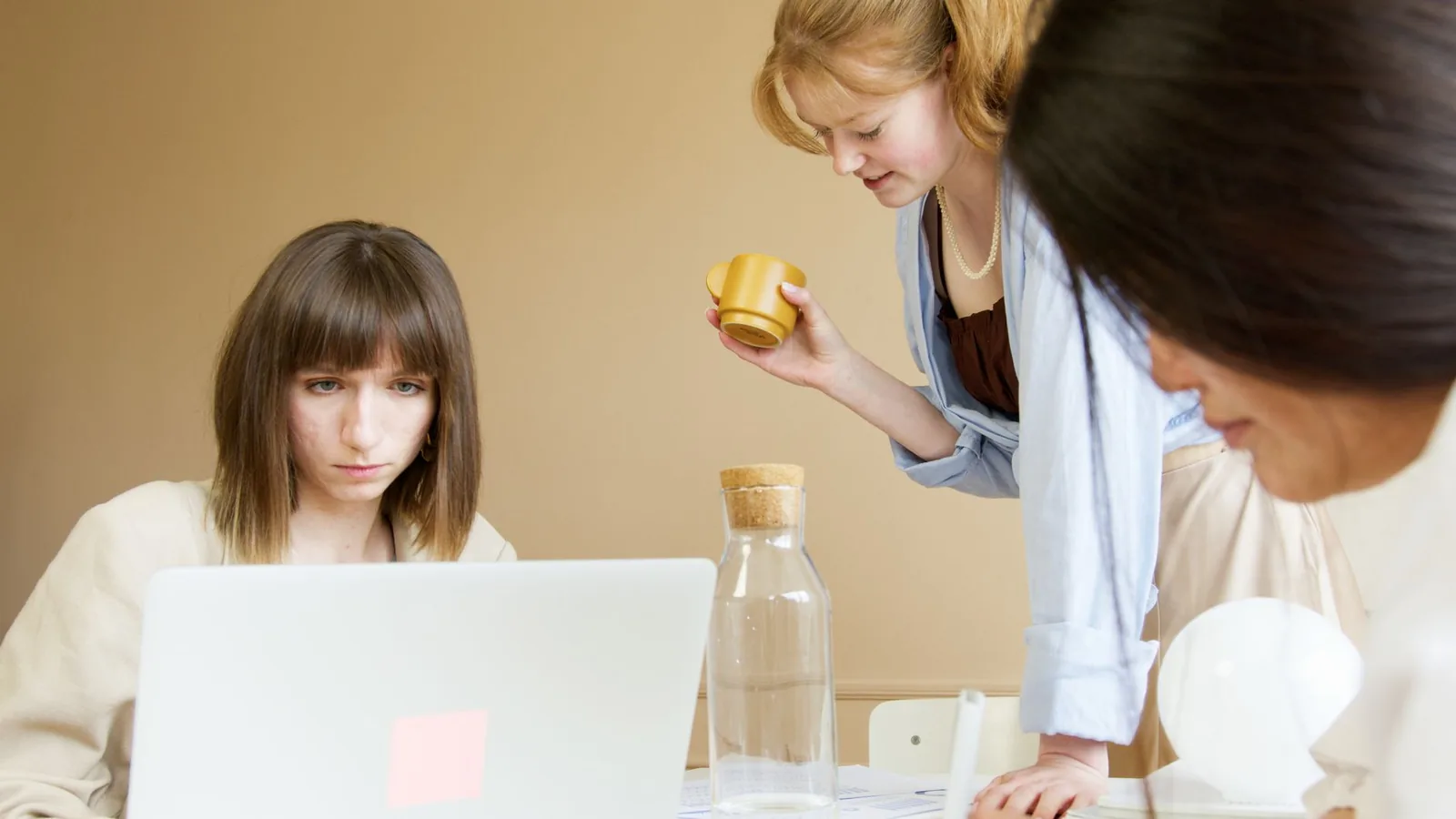 Réunion commerciale en entreprise autour d’un ordinateur portable — assistant IA connecté au CRM